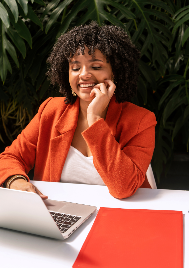 Photo d'une Femme entrepreneure souriante travaillant sur son business en ligne, symbole de réussite et d’épanouissement professionnel.